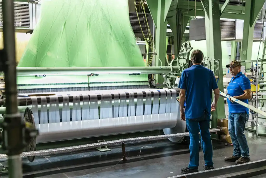 American made upholstery fabric employees watching the weaving process at local textile mill in North Carolina
