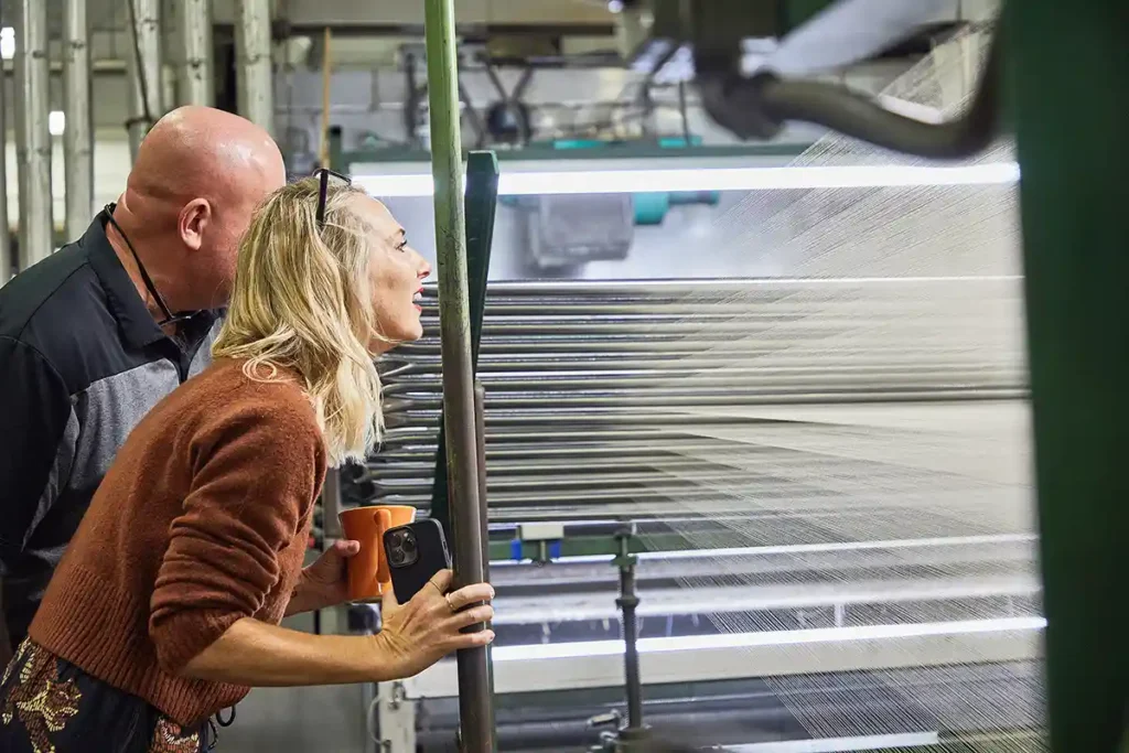 Warping machine prepares yarn for the loom at local textile mill. American made fabric