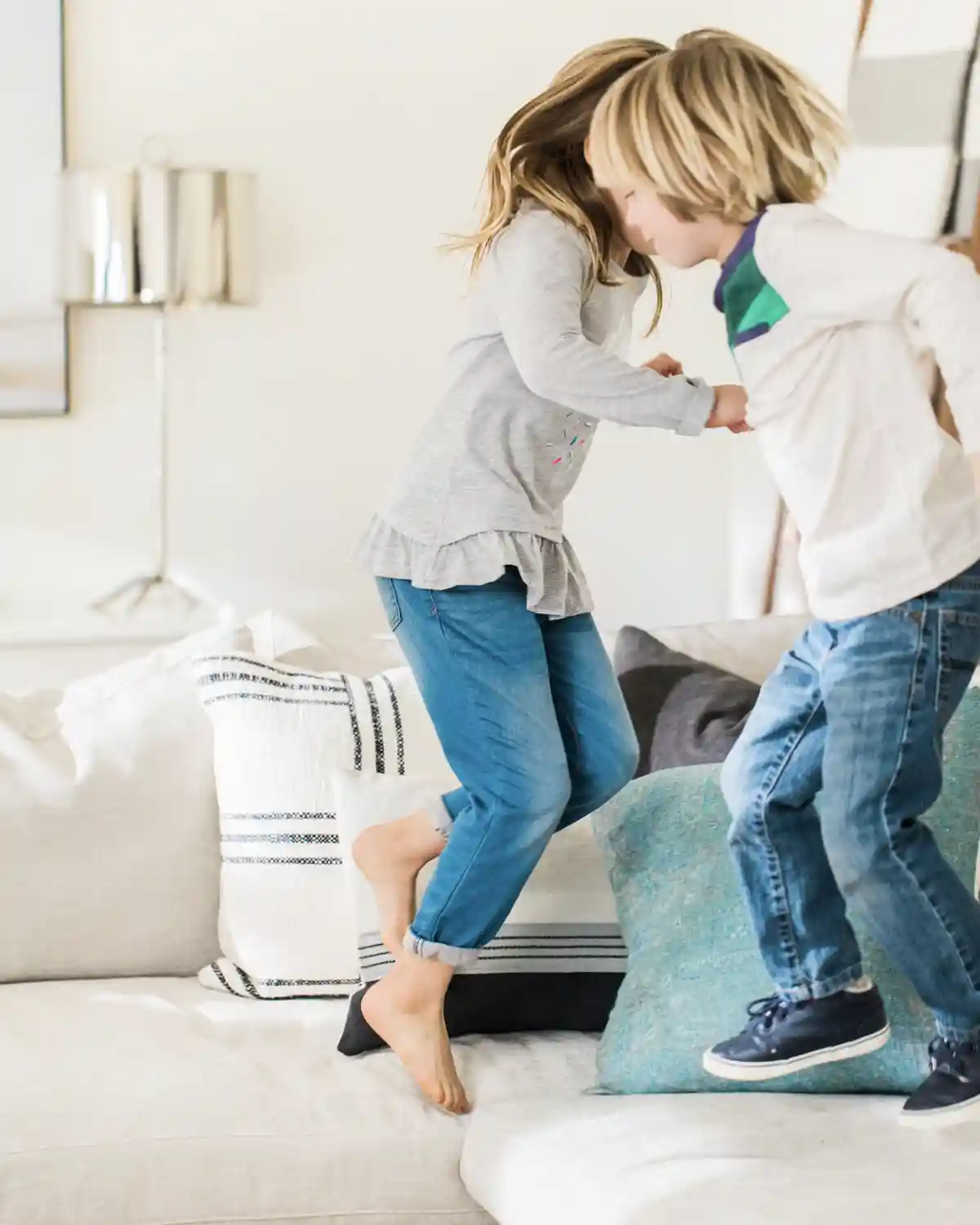 two kids jumping on a kid-friendly upholstered couch
