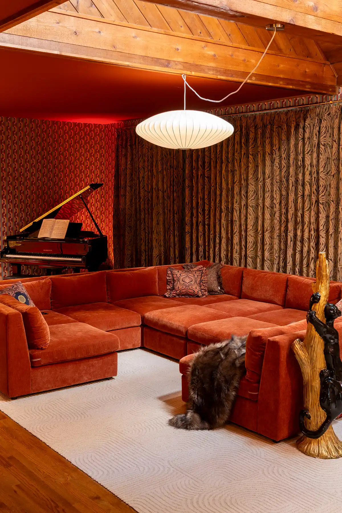 Retro kitsch living room design with animal print curtains and velvet rust sectional