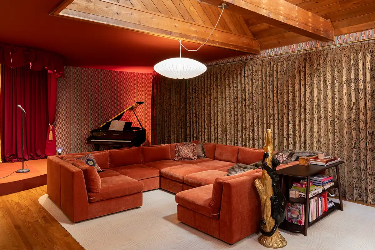 Retro kitsch living room design with animal print curtains and velvet rust sectional