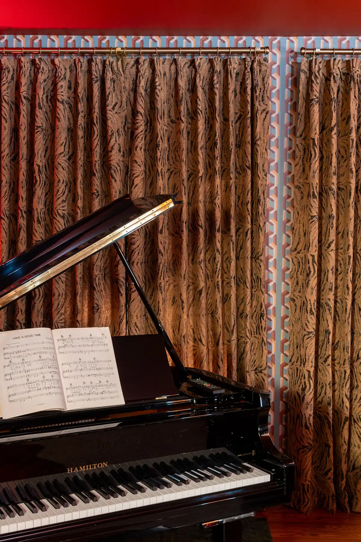 animal print curtains are the backdrop for baby grand piano