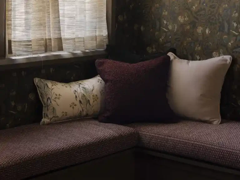 A cozy nook with banquette upholstered in burgundy color performance fabric in the newly designed Garden & Gun magazine headquarters