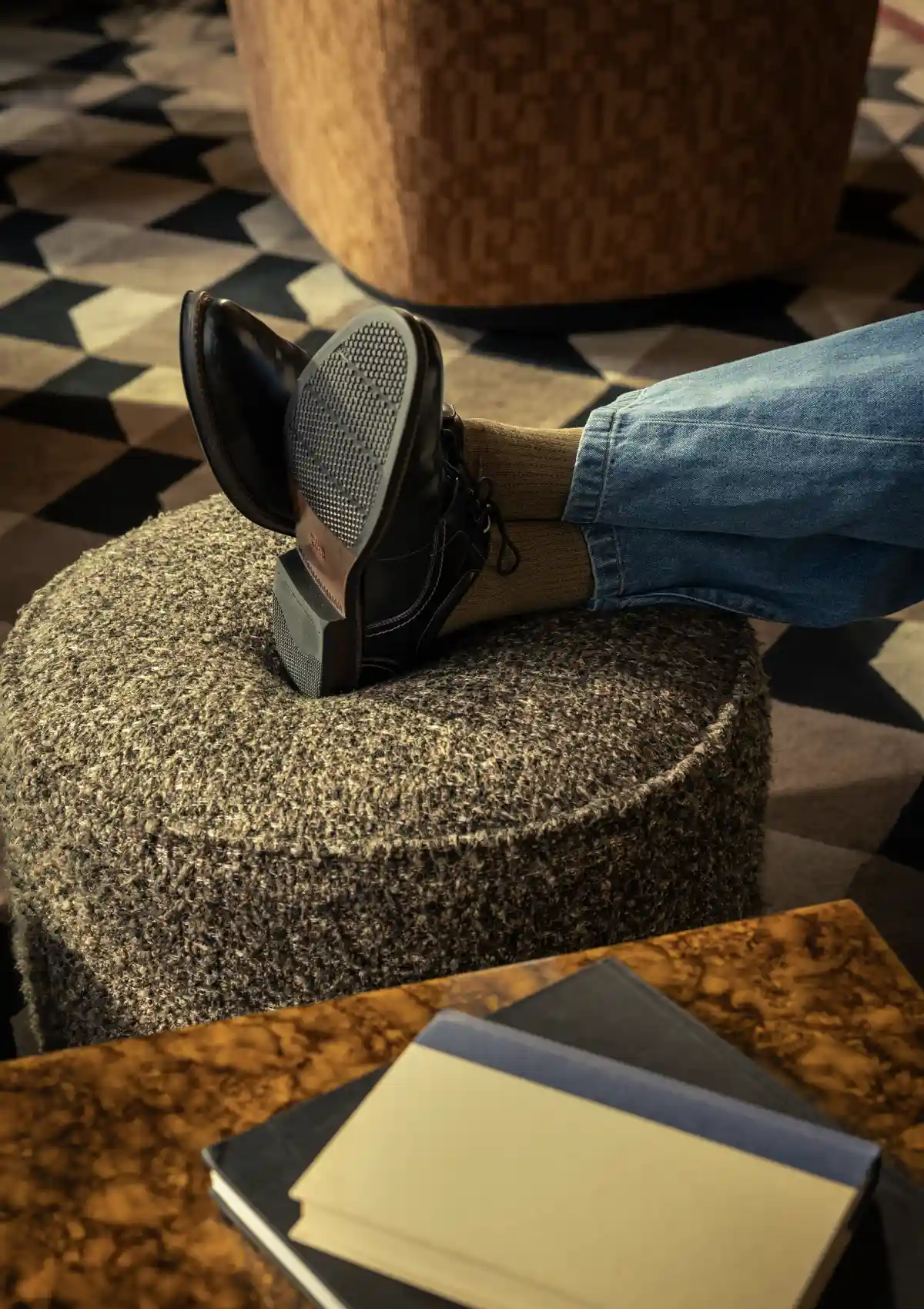 man putting feet up on ottoman in hotel lobby