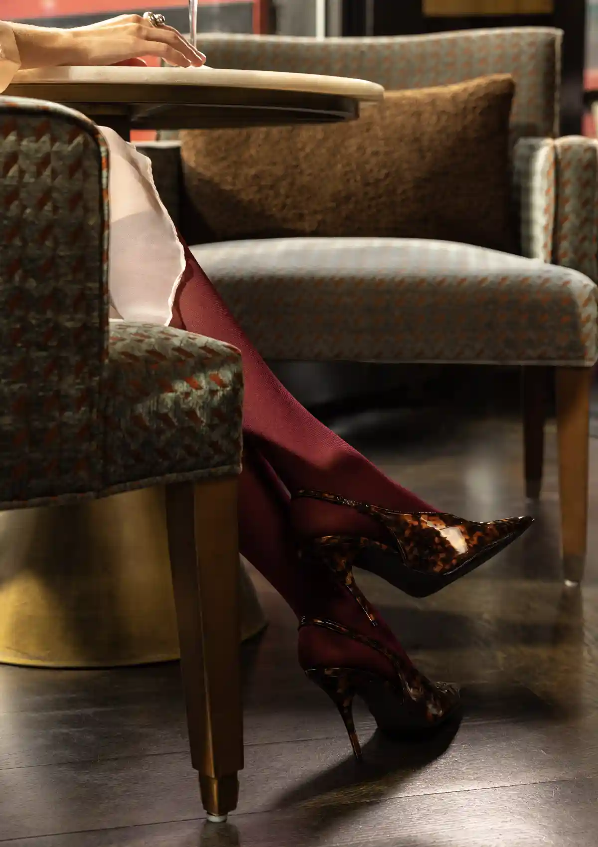 woman sitting in upholstered chair in restaurant 