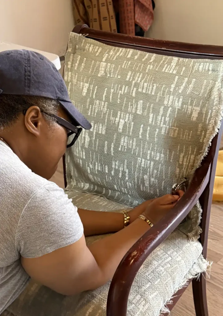 Student stapling fabric to chair