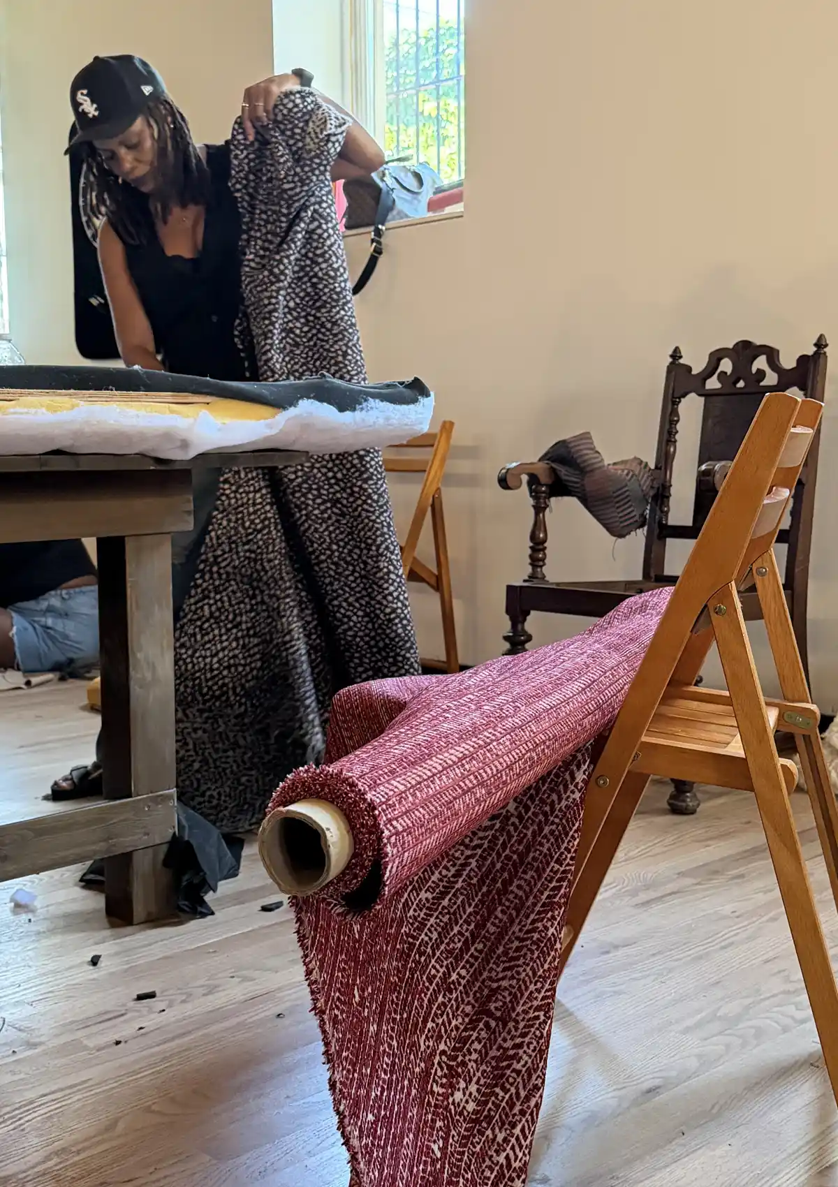 Woman holding roll of upholstery fabric